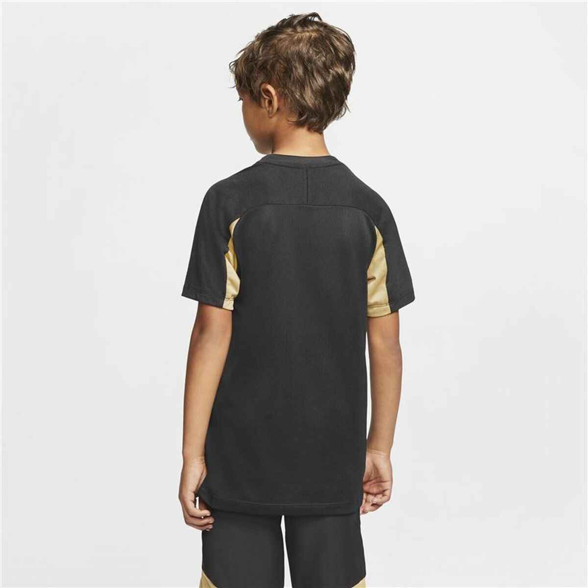 Back view of boy wearing black and beige short-sleeve sports shirt and matching shorts