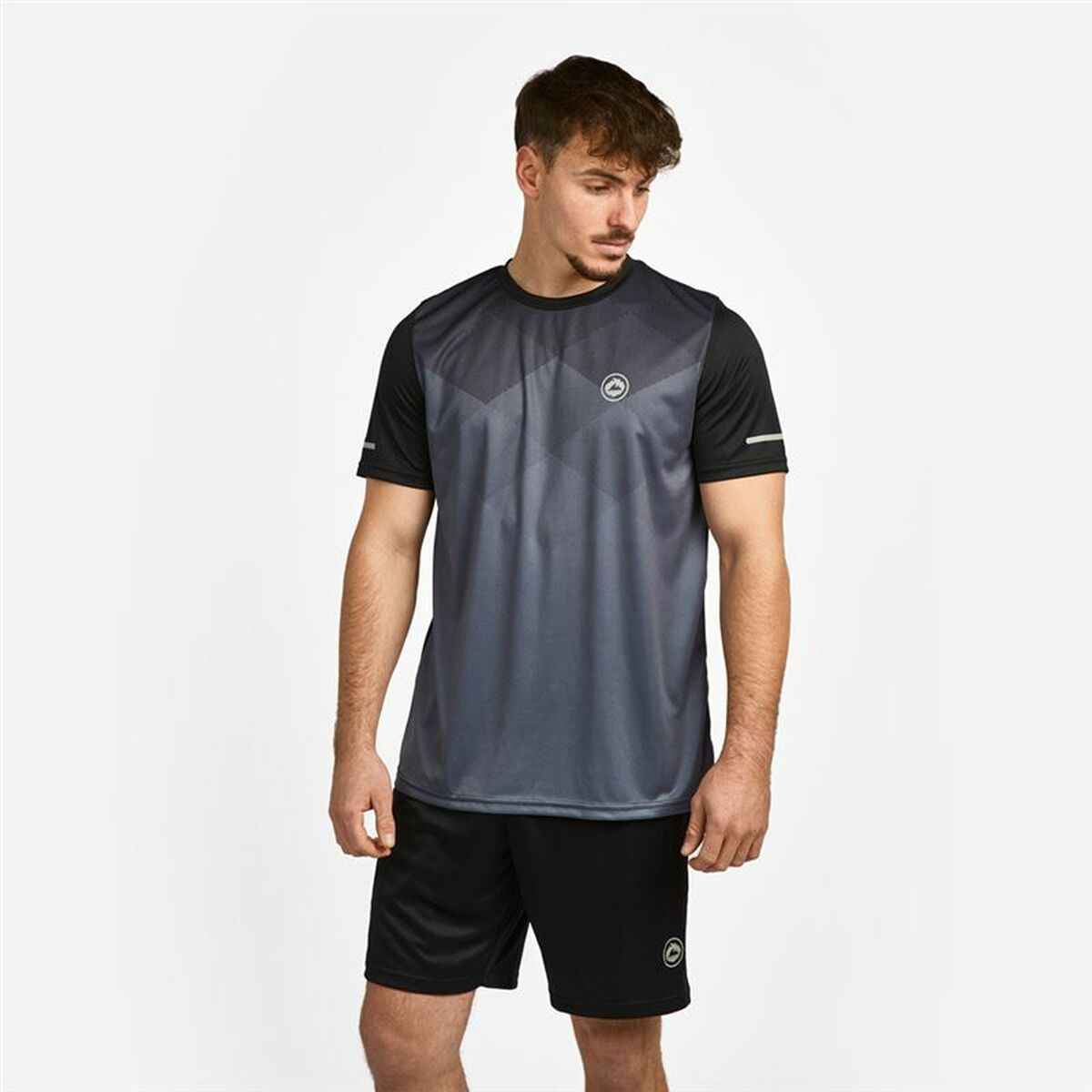 Man wearing black and gray geometric pattern sports t-shirt and black shorts against white background