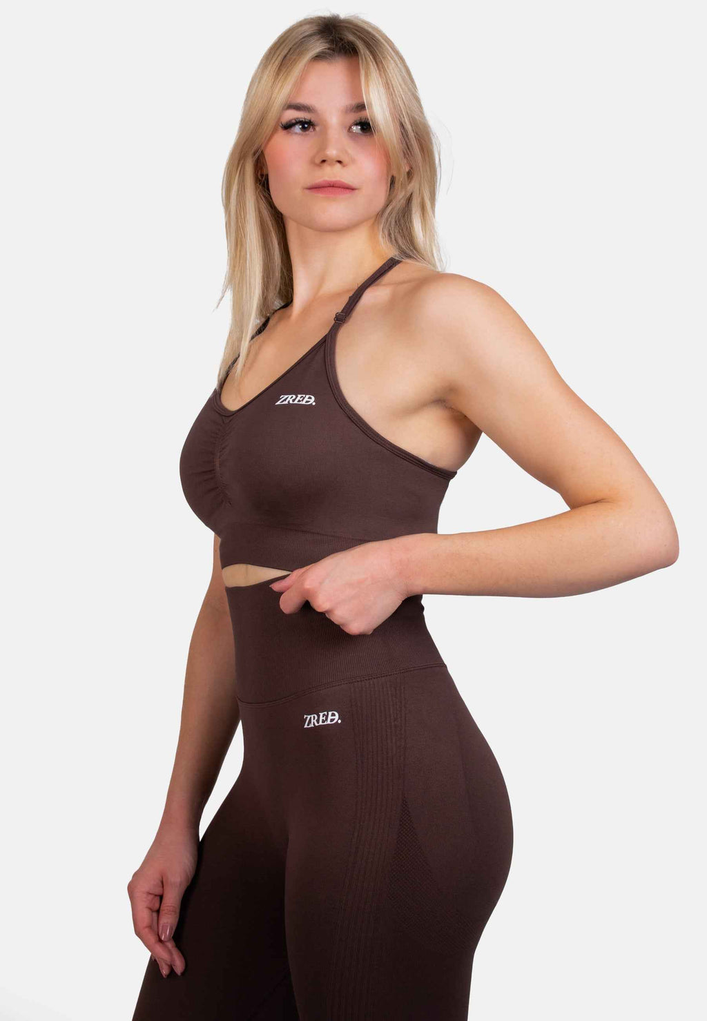 Shape Seamless Sports Bra in brown with removable pads and adjustable straps on a model, paired with matching leggings.
